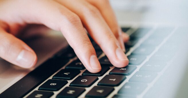 Fingers touching a computer keyboard